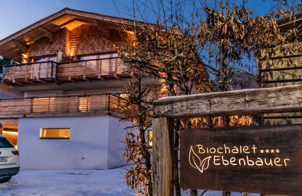 Biochalet Ebenbauer mit Holzschild am Abend in Schladming